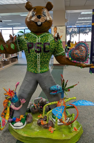 This is an image of a our mascot Parker with two brightly colored alebrijes at his feet.